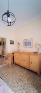 a living room with a wooden cabinet and a chandelier at Lefterakis place in Aegina Town