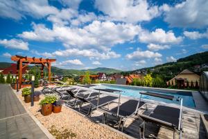 una piscina con sedie e un gazebo di Apartamenty Black Lion a Pcim