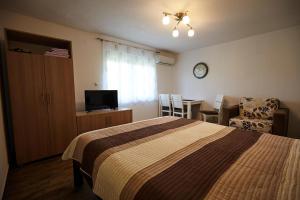 ein Schlafzimmer mit einem Bett und einem Tisch mit einem Stuhl in der Unterkunft Apartment Azulmburgo in Vrnjačka Banja