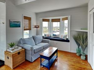 a living room with a couch and a window seat at The Last Dollar Cottage in Topsail Beach