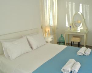 a bedroom with a white bed with towels on it at Alexandra's Sea Front Villa in Pefki