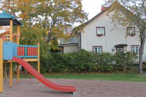 a playground with a slide in front of a house at Hotel Palo in Naantali