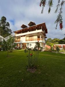 a large white house with a green yard at Casa Oxapampa in Oxapampa