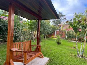 a wooden porch swing with a large umbrella at Casa Oxapampa in Oxapampa