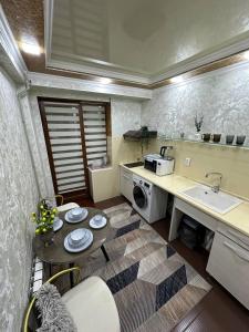 una cucina con lavandino e tavolo con piatti di Квартира 1 ком Тауке хана 33 a Shymkent