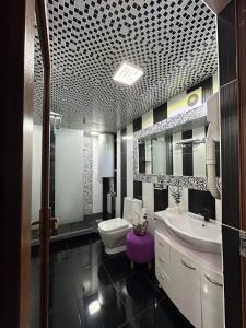 un bagno con due lavandini, un water e uno specchio di Квартира 1 ком Тауке хана 33 a Shymkent Altre 13 foto