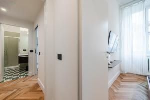 a hallway with white walls and a sliding door at Spacious Apartment in Central Milan Next to Metro in Milan +17 photos