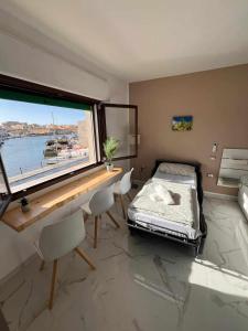 a bedroom with a bed and a desk and a window at Old Port la Marina - Luna in Mazara del Vallo