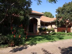 une maison avec un jardin et une allée dans l'établissement Mind-Body-Soul Guesthouse on Featherbrooke Estate, Krugersdorp, South Africa, à Krugersdorp