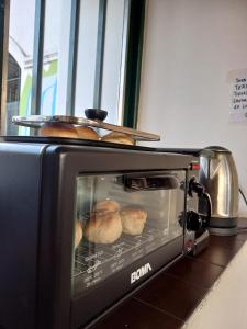 a toaster oven with bread inside of it at Rodex Hostel Tucuman in San Miguel de Tucumán