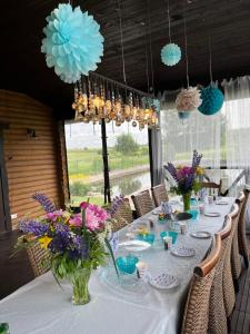 ein langer Tisch mit Blumen in Vasen darauf in der Unterkunft Vila Trakai in Trakai + 75 Fotos