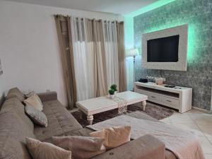 a living room with a couch and a flat screen tv at כוכב ים in Eilat