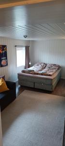 ein Schlafzimmer mit einem Bett in einem Zimmer mit einem Fenster in der Unterkunft Sokkelleilighet rett ved Saltstraumen in Bodø