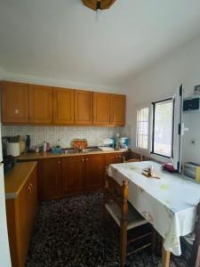 a kitchen with wooden cabinets and a table in it at Garden Guesthouse in Skala Kallirachis