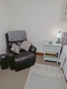 a living room with a leather chair and a table at Walkable Uptown area, King Suite, Quiet and Private in Charlotte