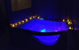 a blue tub with lights in a dark room at Le Studio - Saint Jean de Maurienne in Saint-Jean-de-Maurienne