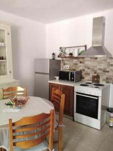 a kitchen with a table and a stove top oven at Nostalgia Apartment A in Sami 50 metres from the sea in Sami