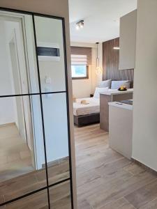 ein Wohnzimmer mit Bett und ein Zimmer mit Glasschiebetür in der Unterkunft Golden View with Balcony in Ammoudara