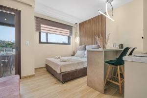 ein Schlafzimmer mit Bett und Schreibtisch und eine Küche in der Unterkunft Golden View with Balcony in Ammoudara