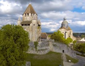 an old castle in the middle of a city at Gite "C" dans une ancienne corps de ferme C in Poigny