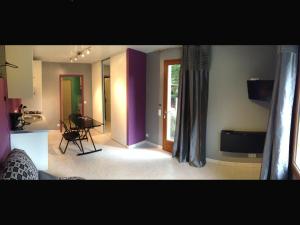 uma sala de estar com paredes roxas, uma mesa e uma janela em Le Studio - Saint Jean de Maurienne em Saint-Jean-de-Maurienne
