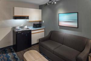 a living room with a couch and a kitchen at Accent Inns Vancouver Airport in Richmond