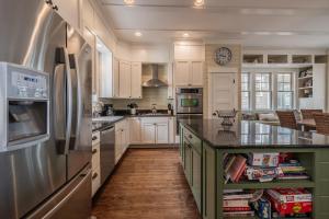 a kitchen with white cabinets and a stainless steel refrigerator at Nantucket House by Seabrook Hospitality in Pacific Beach