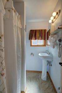 baño blanco con lavabo y ventana en Westerly Motel en Ocean Shores