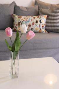 a vase with pink flowers sitting on a table at Lazaros 1BDR Suite 3 min walk to Finikoudes beach in Larnaca