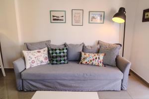 a couch with pillows on it in a living room at Lazaros 1BDR Suite 3 min walk to Finikoudes beach in Larnaca