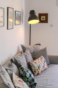 a room with a couch with pillows and a lamp at Lazaros 1BDR Suite 3 min walk to Finikoudes beach in Larnaca