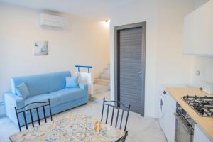 Una sala de estar con un sofá azul y una cocina. en Case Vacanze Villa Patrizia, en Marinella di Selinunte
