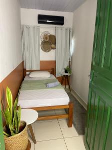 a small bedroom with a bed and a table at Hostel Native in Boa Vista