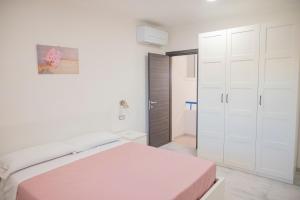Un dormitorio blanco con una cama y un armario. en Case Vacanze Villa Patrizia, en Marinella di Selinunte