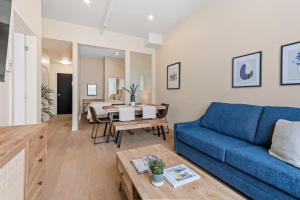 a living room with a blue couch and a table at City Center 2BR Condo in Montreal