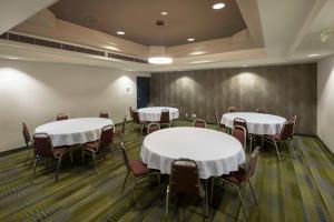 uma sala de conferências com mesas e cadeiras brancas em Accent Inns Burnaby em Burnaby