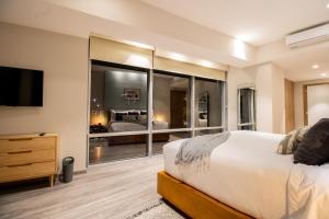 a bedroom with a bed and a large mirror at Capitalia Plaza Residences Reforma in Mexico City