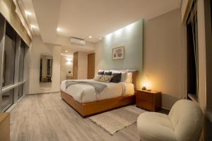 a bedroom with a bed and a chair at Capitalia Plaza Residences Reforma in Mexico City +20 photos