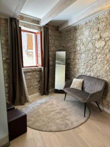 a living room with a chair and a mirror at Studios OneThreeFive in Rovinj