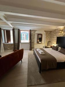 a large bedroom with a large bed and a couch at Studios OneThreeFive in Rovinj