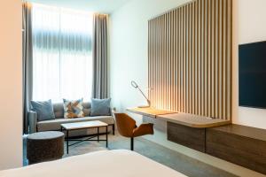 a hotel room with a bed and a desk and a couch at Courtyard by Marriott Amsterdam Arena Atlas in Amsterdam