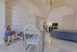 a bedroom with a bed and a table and chairs at Masseria Conca D'Oro in Ostuni