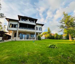 a large house with a green lawn in front of it at Вила Нибела in Elechanova