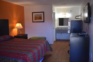a hotel room with a bed and a kitchen at Stay Express Inn North Charleston in Charleston