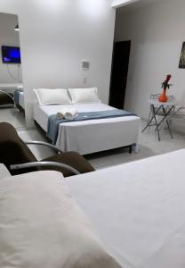 sypialnia z 2 łóżkami, stołem i krzesłami w obiekcie SUITE ELEGACY w mieście Serra de São Bento