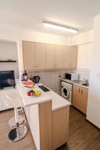 a kitchen with a counter with a plate of fruit on it at Finikoudes Seaview Vibe 1 Bdr Flat in Larnaka