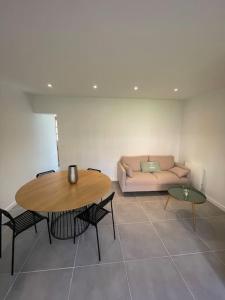 a living room with a table and a couch at Charmante dépendance avec jardin in Vaux-sur-Seine