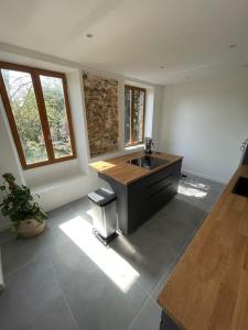 a kitchen with a sink and a counter top at Charmante dépendance avec jardin in Vaux-sur-Seine +2 photos
