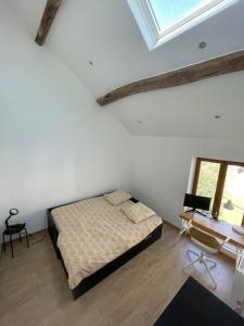 a bedroom with a bed and a desk and window at Charmante dépendance avec jardin in Vaux-sur-Seine