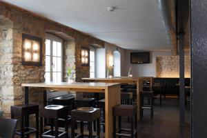 un restaurant avec des tables et des tabourets dans une pièce dans l'établissement OX Hotel, à Heitersheim